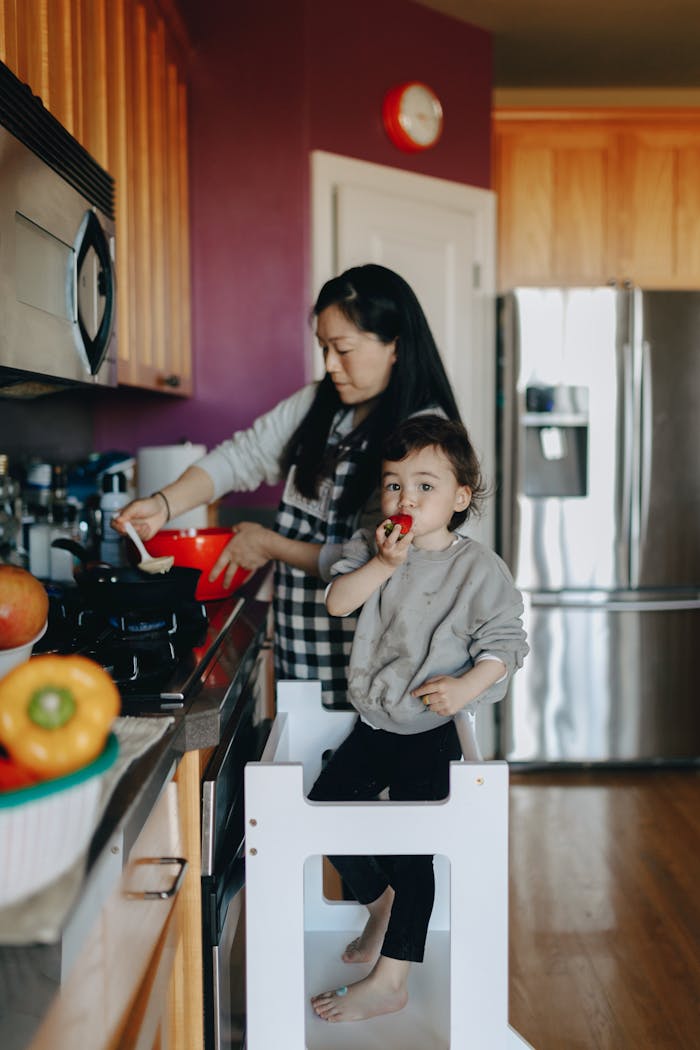 A mother and child cooking together in a modern kitchen, creating a moment of family bonding.