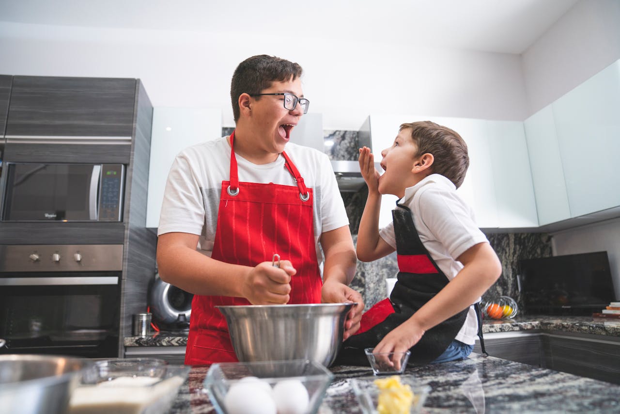 A father and son joyfully baking together in a modern kitchen, sharing laughter and bonding over a delicious recipe.